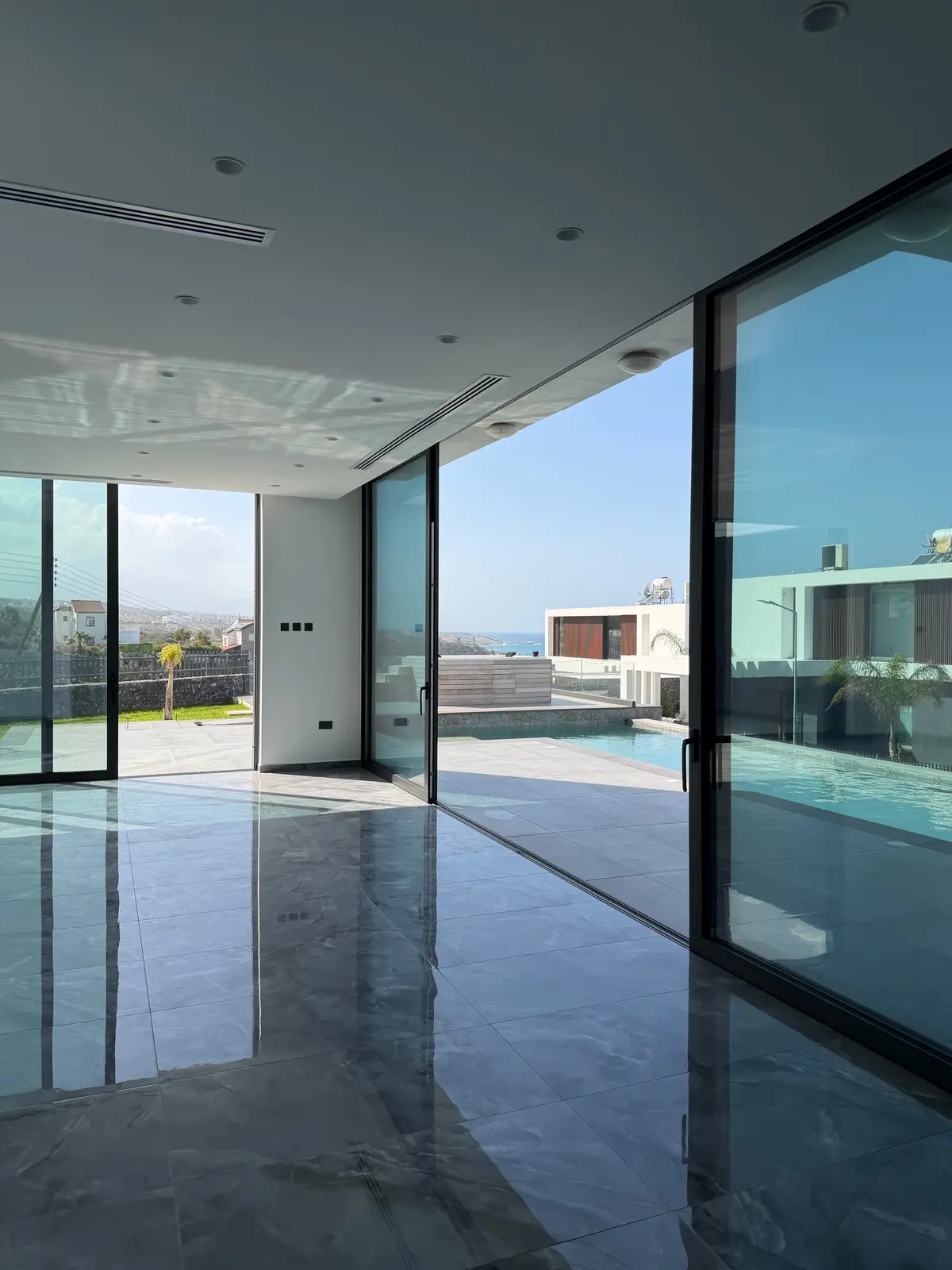 Lichtdurchfluteter Wohnbereich der Esentepe-Villa mit bodentiefen Fenstern und Blick zum Pool