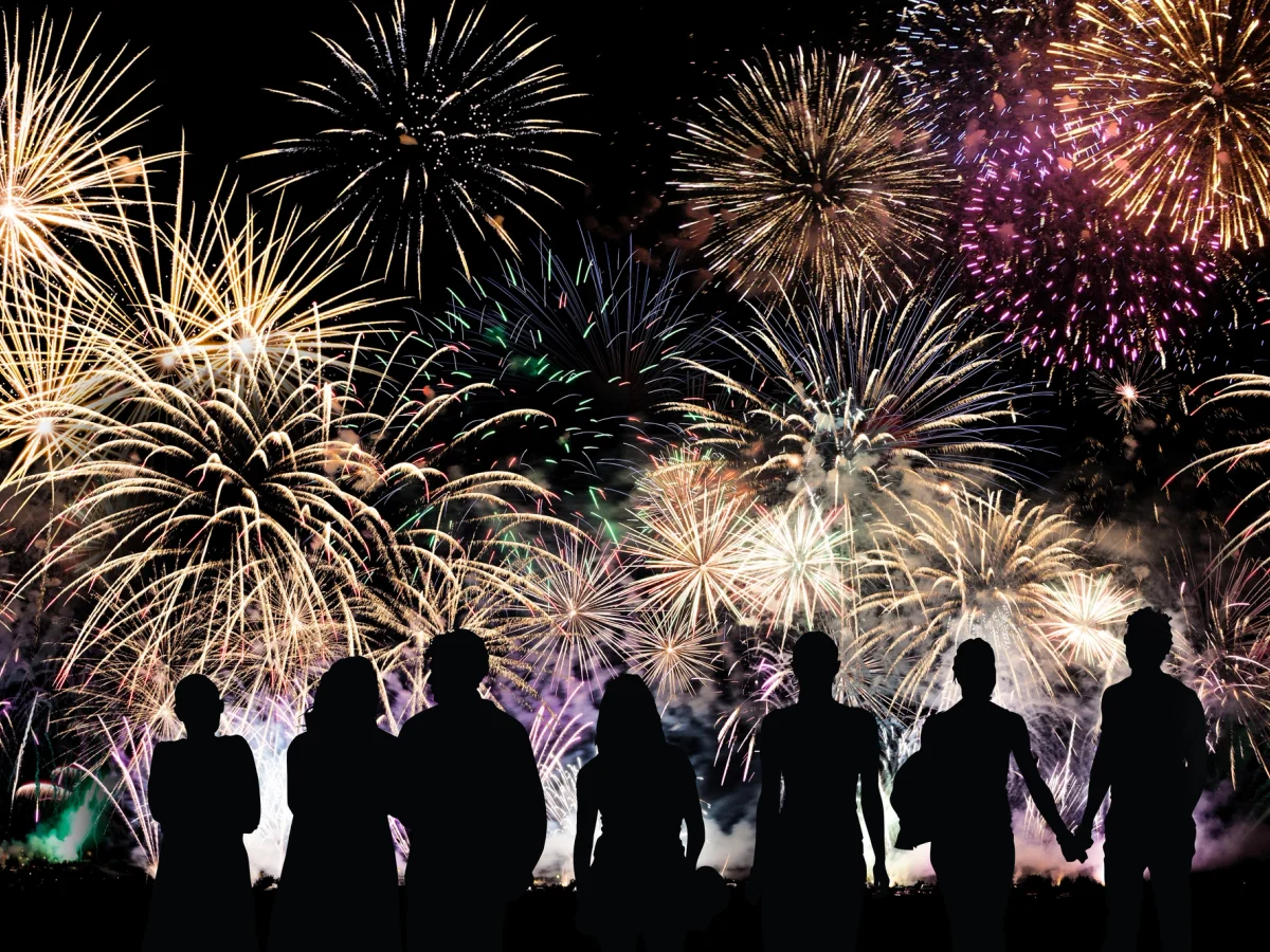 Menschen vor einem Silvesterfeuerwerk