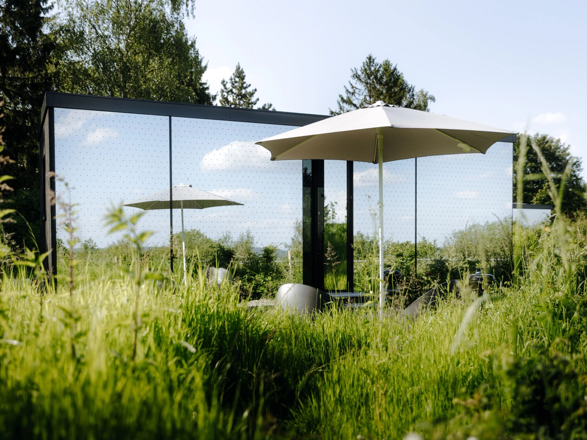 Außenbereich mit Sonnenschirm am Tiny House, moderne Minihäuser für nachhaltiges Wohnen