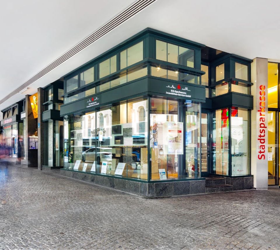 Moderne und einladende Fassade des SIS-Immobilien-Ladenlokals in München.