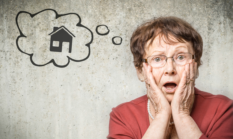 Erschrockene ältere Frau mit einer Gedankenblase in der ein gezeichnetes Haus zu sehen ist.