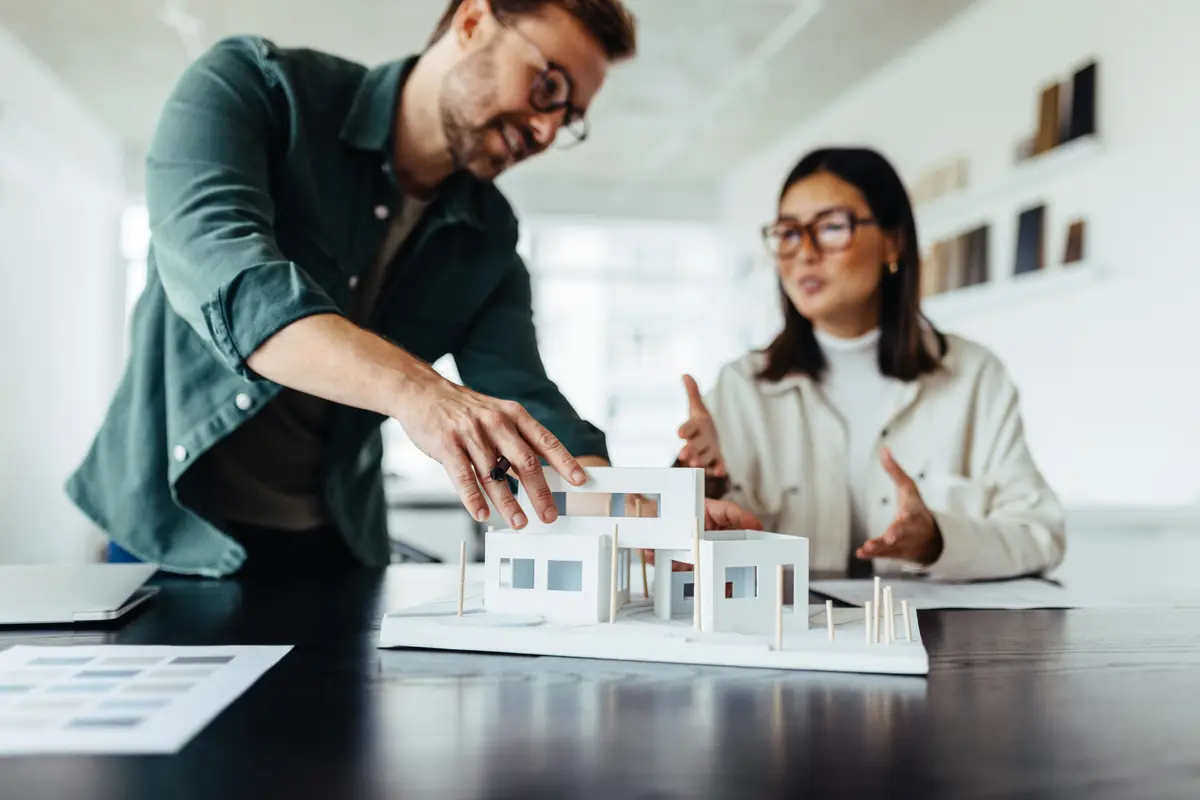 Architects working on a house model in an office Architekten im Büro
