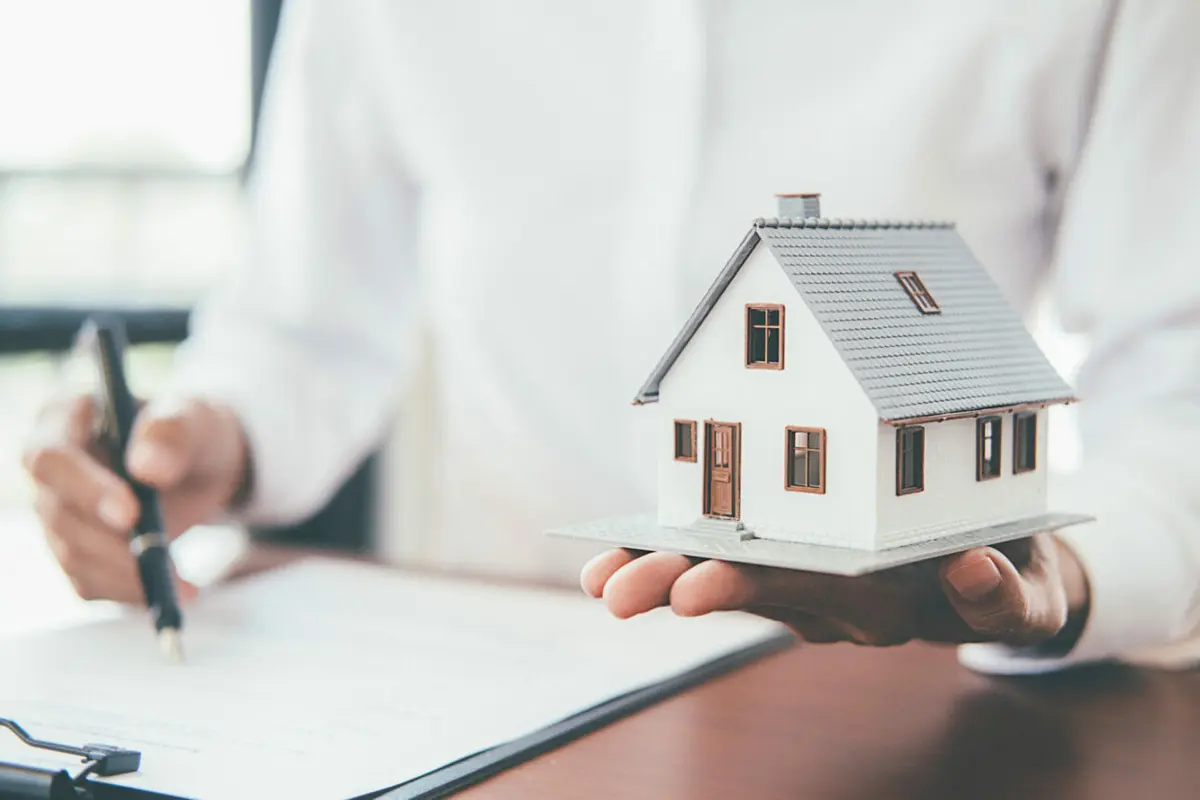 House model with real estate agent and customer discussing for contract to buy house, insurance or loan real estate background. Haus auf Händen 2