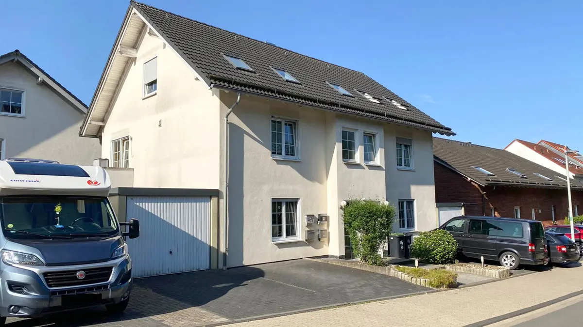 Ansicht des Hauses von links vorne mit 2 Stellplätzen und 1 Garage