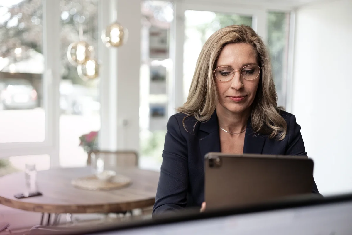 Katja Bremer arbeitet mit einem Tablet an einer Immobilienanalyse