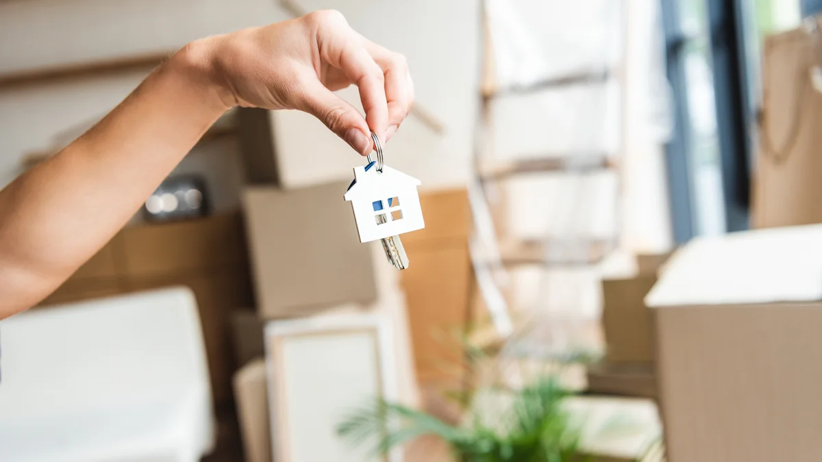 Übergabe eines Wohnungsschlüssels zwischen Umzugskartons