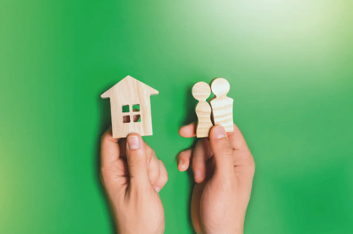 Hand mit Haus und Figuren