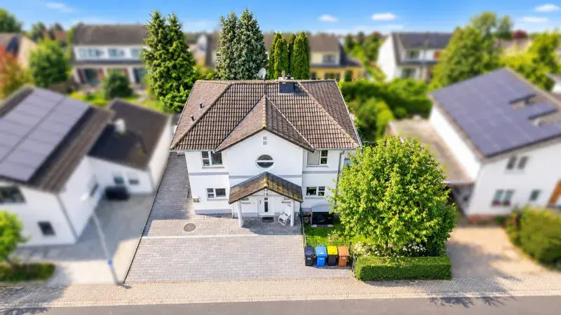 Sonniger Vorort mit weißem Traumhaus
