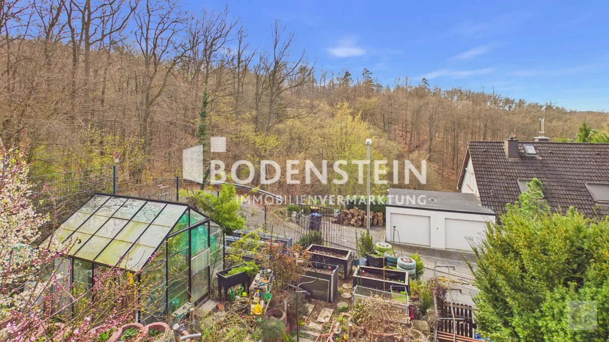 Blick auf Gewächshaus und Hochbeete