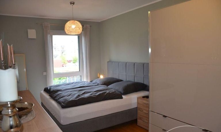 Schlafzimmer mit Blick zu Fenster und Gr&szlig;em Kleiderschrank