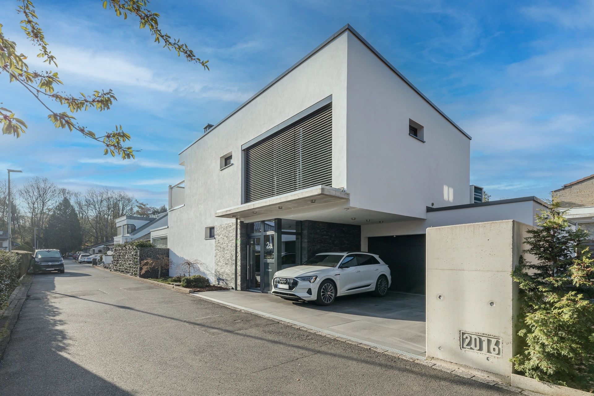 Modernes Neubauhaus mit Glasfassade bei Sonnenuntergang – Ihr Immobilienmakler in Siegburg für Design und Wohnqualität