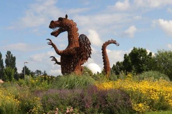 Drachen Skulptur in Wachtberg Berkum zwischen Blumen und Wiese