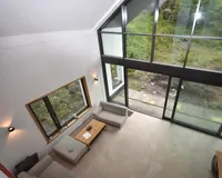 hoher Wohnraum mit Giebelfenster zum Garten