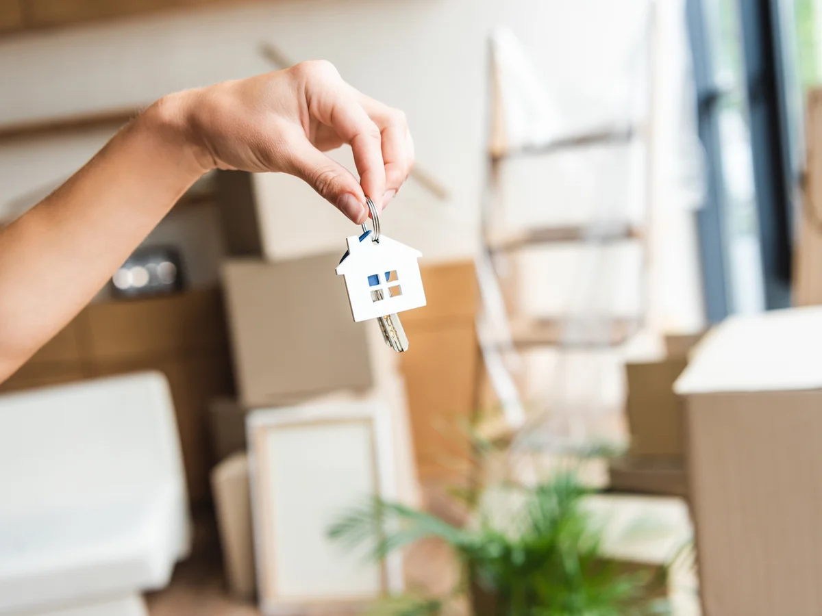 Übergabe eines Wohnungsschlüssels zwischen Umzugskartons