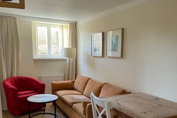 Wohnung im Souterrain einer Stadtvilla, Wohnraum mit Tisch u.Sesseln