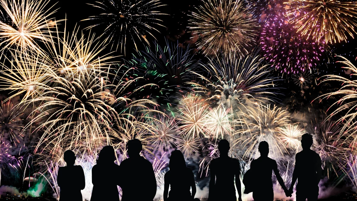 Menschen vor einem Silvesterfeuerwerk