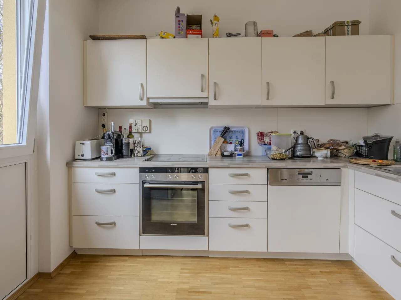 Offene Küche mit Fenster und angrenzender Abstellkammer