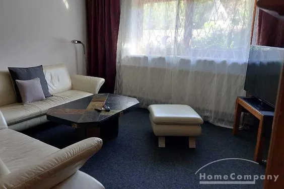 Wohnung im Souterrain eines Reihenhauses, großes Wohnzimmer mit TV