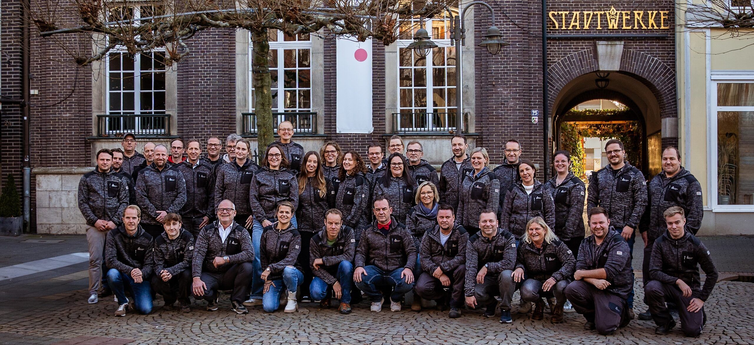 Die Mitarbeitenden der Stadtwerke vor dem Gebäude der Stadtwerke am Markt